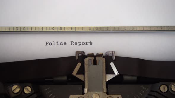 Typing phrase Police Report on retro typewriter. Close up. alt