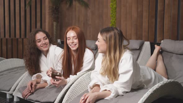 Young Goodlooking Women Spending Time in Spa Resort Hotel Salon Girlfriends Enjoying Herbal Tea