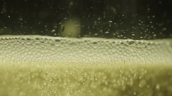 Lite Beer poured into a glass close up with a  black background in slow motion alt