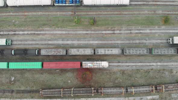 Drone top view of cargo freight trains and railway tracks in industrial part of city alt