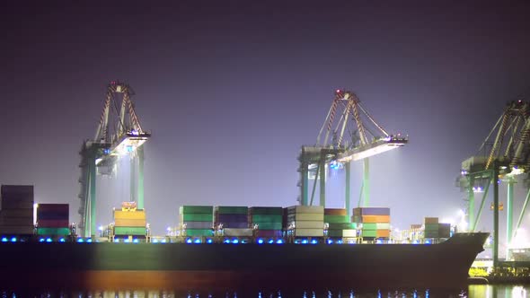 Loading a container ship at night, ZOOM IN EASE. alt