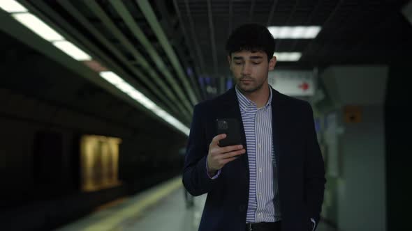 Man in Suit Using Smartphone While Waiting for Subway alt
