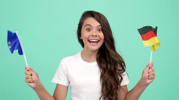 Amazed Happy Child Waving European Union and German Flag Celebrating Success and Victory Victory alt