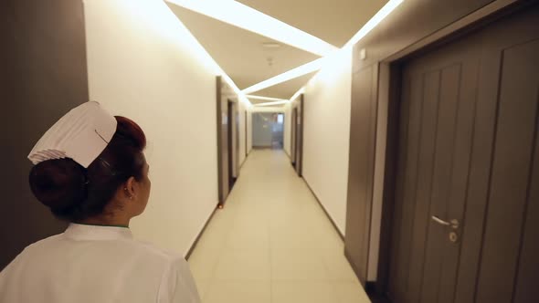 Nurse Walks Through Hospital Ward  alt
