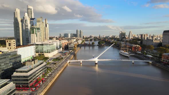 Cinematic aerial pull out view of Woman's Bridge in Puerto Madero, Buenos Aires alt