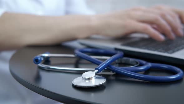 The doctor works on a laptop.  alt