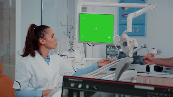 Woman Analyzing Green Screen on Monitor and Teeth x Ray alt