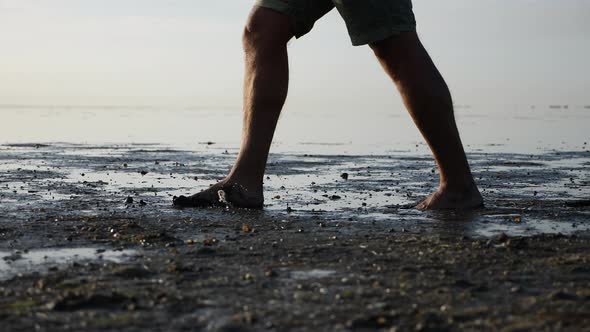 Cinematic Shot of Man with Dirty Feet Walking Barefoot Near Pond