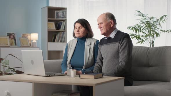 Married Couple Feeling Unwell Communicates with Doctor Online Via Video Call on Laptop While Sitting alt