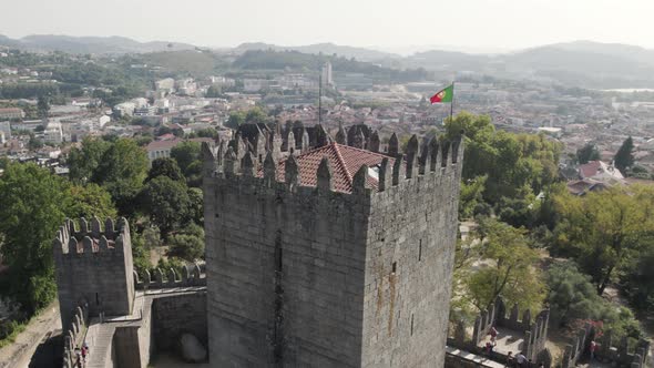 Aerial orbit watchtower of Guimaraes Medieval Castle, City buildings background