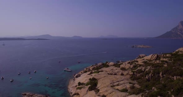 Aerial, Sardinia Island And Its Rocky Shore, Beautiful Emerald Sea And Tavolara Island On Background