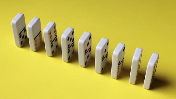 Pushing a row of dominoes with a finger.