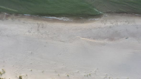 AERIAL: Descending Top View Shot of Sandy Beach with Seashore and Baltic Sea Seaside alt