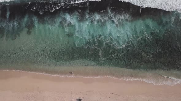 Aerial Top View of Ocean Waves Break on a Beach