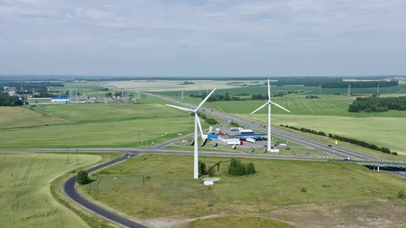 Aerial View Windmills Wind Turbines Producing Clean Ecological Electricity By Road in Green alt