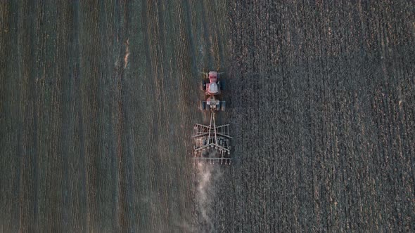 Aerial Top View of Farm Machinery Working on Cultivated Field alt