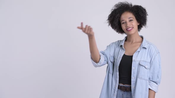Happy Young Beautiful African Woman Snapping Fingers and Showing Something alt