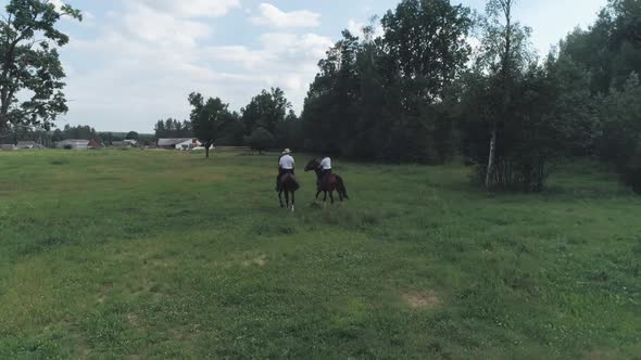 Family Outdoor Recreation Man Cowboy and a Woman Riding a Horse in a Clearing Near the Forest View alt