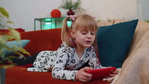 Worried Teen Child Girl Kid Enthusiastically Playing Shooter Video Online Game on Smartphone at Home alt