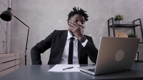 Young Businessman Analyzes the Financial Graph on a Laptop in the Office alt