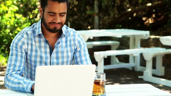 Man using laptop while having beer 4k alt