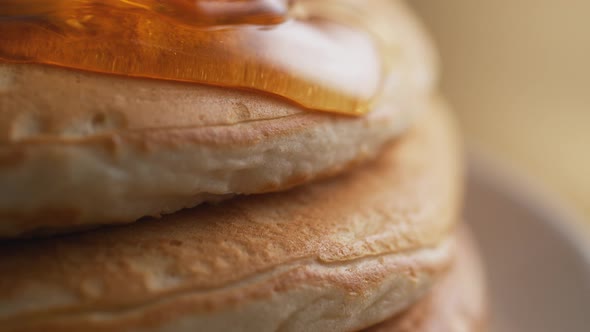 Honey on stack of pancake. Slow Motion. alt