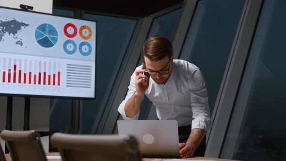 Young man communicating with a customer using a phone in workplace alt