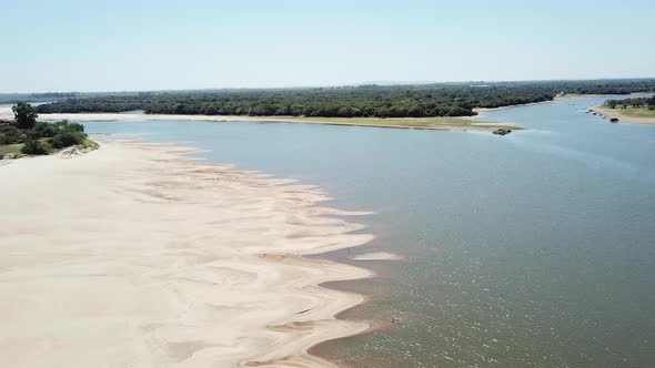 Drone descending over a river in dry season on a sunny day. alt