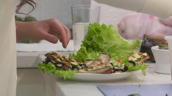 Woman Cooking Festive Dinner in the Kitchen Making Toast with Cucumber and Caviar alt