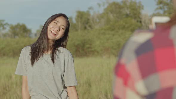 Teenage females take pictures on the smartphone while sunset having fun together a summer traveling.