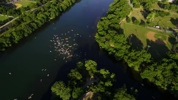 Aerial view of a group of SUP boarders on the Colorado river with Austin skyline in the background - alt