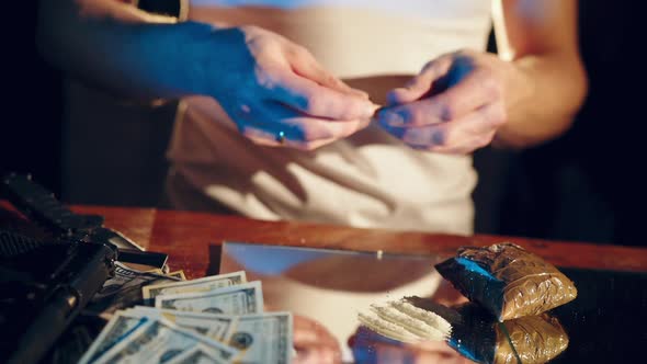 Gangster holding a folded bill for sniffing and snorting the line. Criminal business alt