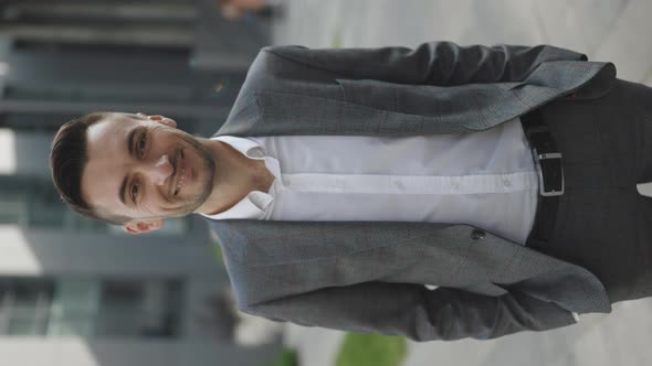 Vertical Video Portrait of Handsome Businessman Standing Look at Camera Smiling Near Business Center alt