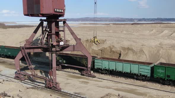 Loading Sand Into Rail Cars with the Help of a Career Excavator