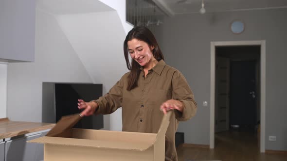 Satisfied Stylish Asian Woman Opens Parcel Carton Box Unpacking Received Gift