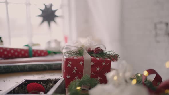A Packaged Gift Stands on the Table and the Camera Flies Around the Table in Slow Motion alt