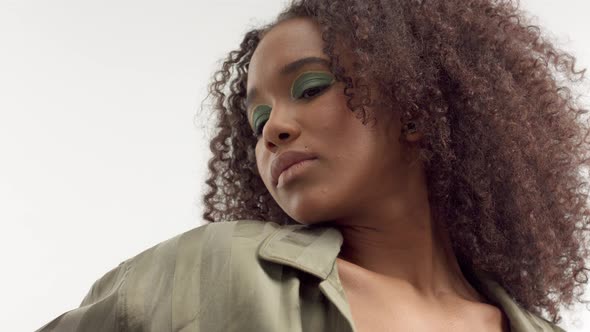 Young Mixed Race Model in Studio on White with Curly Hair, Bright Green Eye Makeup alt