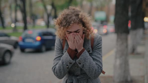Woman with Cold Sneezes in the Street