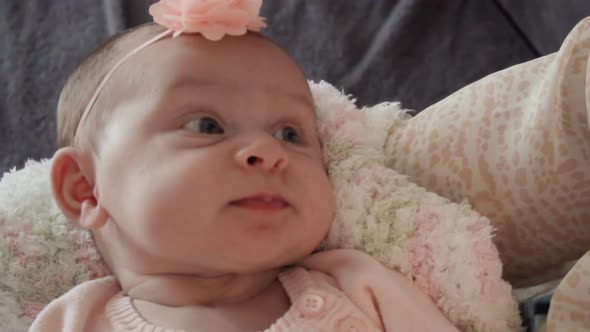Infant baby girl in pink and white stripes outfit. alt