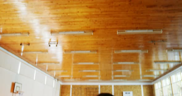 Portrait of schoolboys holding basketball in basketball court alt