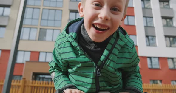 Small Child Riding Carousel Merrygoround Playing on Playground