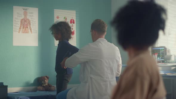 Physician Checking Teen Girl Lungs with Stethoscope alt