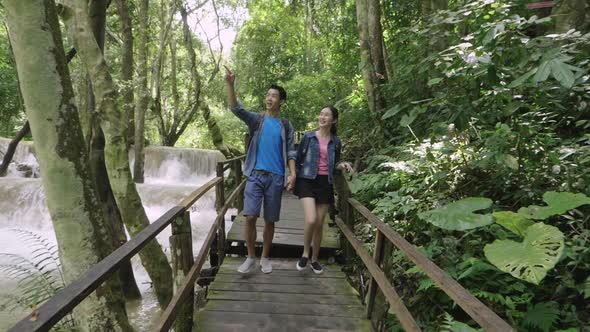 Happy Couple Walking Near A Waterfall alt