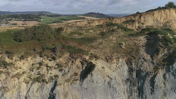 Cliffs at Charmouth. Aerial tracking backwards out to sea, over time more of the cliff is revealed. alt