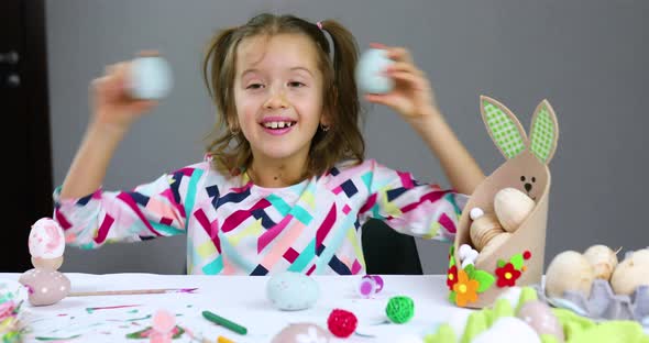 Cute Little Child Girl on Easter Day Hold Easter Egg in Hand Make Faces at Home alt
