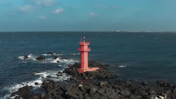 Aerial view. A lighthouse standing in the middle of the sea like an island. Drone View.