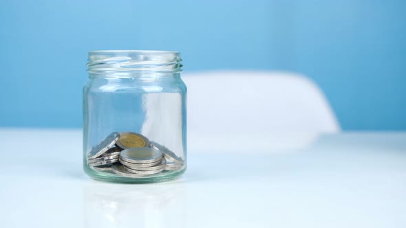 Stop motion animation Coin money into glass jar, Saving money concept
