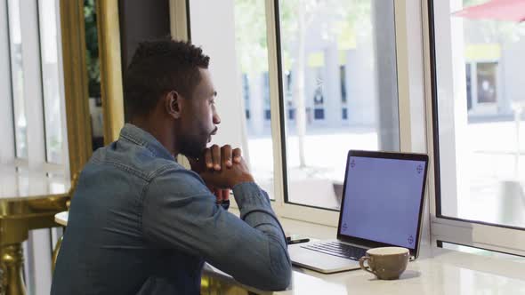 African american businessman using laptop in cafe alt