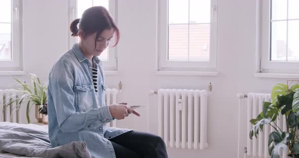 Solitary woman at home looking at photo prints alt