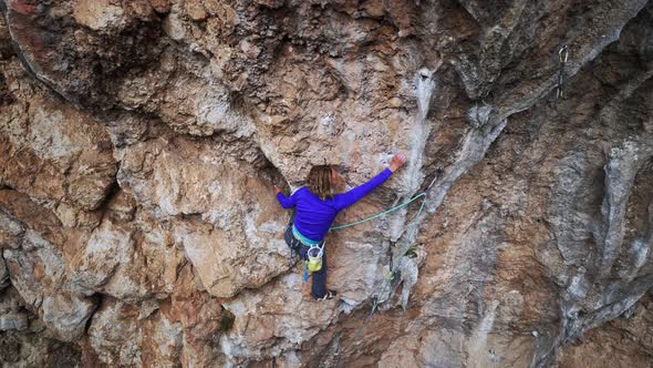 Strong Girl Rock Climber Climbs on Overhanging Crag alt